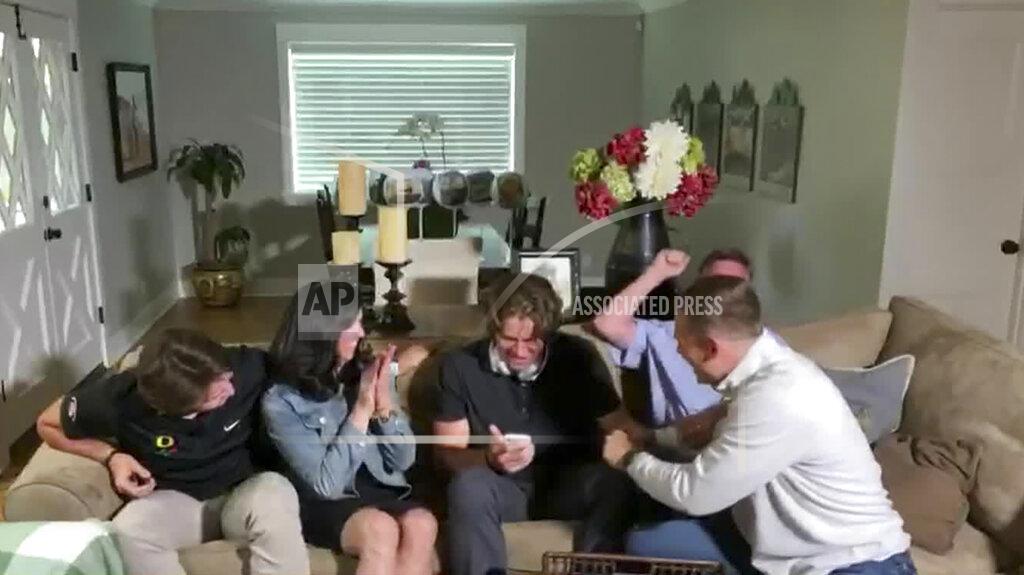 Uncredited In this still image from video provided by the NFL, Justin Herbert holds his phone during the NFL football draft Thursday, April 23, 2020. The Los Angeles Chargers selected Herbert with the sixth pick. (NFL via AP)