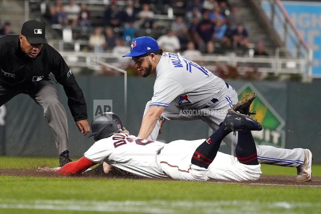 Jim Mone Minnesota Twins' Josh Donaldson, left, beats the tag by Toronto Blue Jays' Breyvic Valera (74) as he dives safely back to third after being caught off the base in the third inning of a baseball game, Thursday, Sept. 23, 2021, in Minneapolis. (AP Photo/Jim Mone)