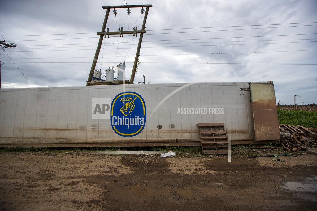 Moises Castillo A Chiquita container sits on the side of the road where it was dragged by floodwaters during last year's hurricanes Eta and Iota at a banana packing plant in La Lima, on the outskirts of San Pedro Sula, Honduras, Wednesday, Jan. 13, 2021. The Sula Valley, Honduras’ most agriculturally productive, was so heavily damaged that international organizations have warned of a food crisis. (AP Photo/Moises Castillo)