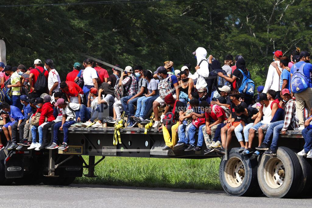 Delmer Martinez Migrants ride on the back of a freight truck as they move through Santa Rosa de Copan, Honduras, Friday, Jan. 15, 2021, in hopes of reaching the U.S. border. The group quickly dispersed along the heavily-trafficked highway to the border town of Agua Caliente, but estimates of their number ranged from 2,000 to more than twice that. (AP Photo/Delmer Martinez)