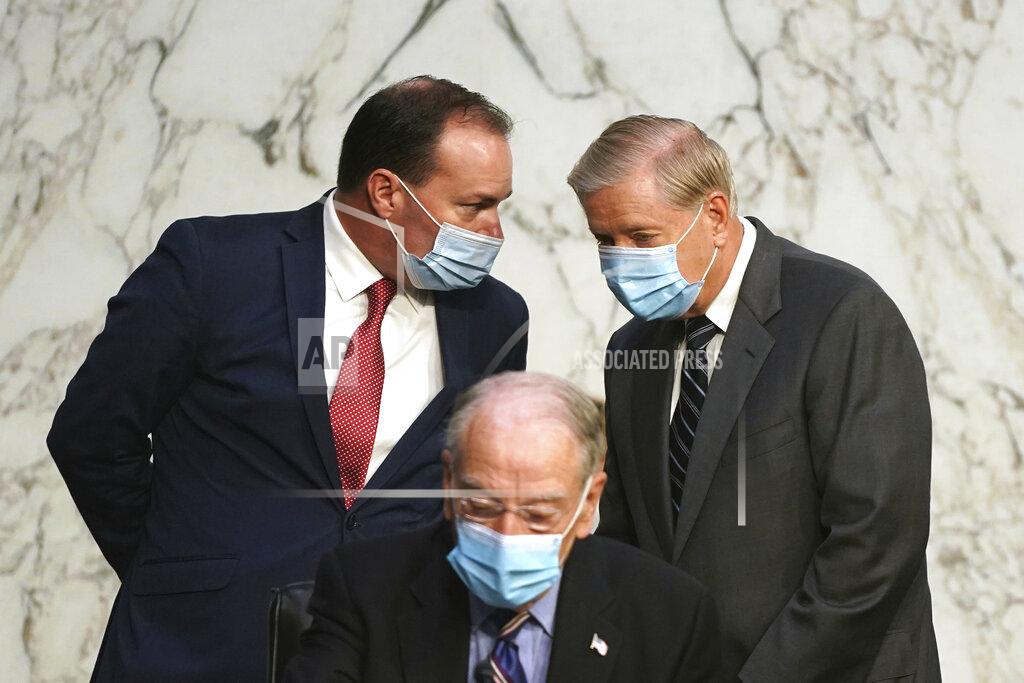 Alex Edelman Sen Mike Lee, R-Utah, talks with Chairman Lindsey Graham, R-S.C., behind Sen. Charles Grassley, R-Iowa, before the confirmation hearing for Supreme Court nominee Amy Coney Barrett at the Senate Judiciary Committee on Capitol Hill in Washington, Monday, Oct. 12, 2020. (Alex Edelman/Pool via AP)