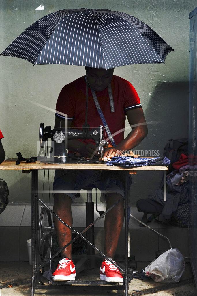 Marco Ugarte FILE - In this Sept. 3, 2021 file photo, a Haitian migrant operates a sewing machine at a market in Tapachula, Mexico. Thousands of mostly Haitian migrants have been stuck in the southern city of Tapachula, many waiting here for months and some up to a year for asylum requests to be processed. (AP Photo/Marco Ugarte, File)