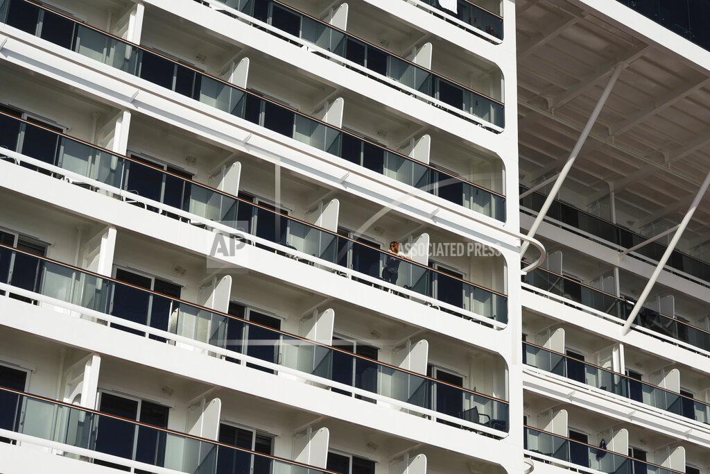 Andrew Medichini A passenger stand on the terrace of a cabin of the MSC Grandiosa cruise ship in Civitavecchia, near Rome, Wednesday, March 31, 2021. MSC Grandiosa, the world's only cruise ship to be operating at the moment, left from Genoa on March 30 and stopped in Civitavecchia near Rome to pick up more passengers and then sail toward Naples, Cagliari, and Malta to be back in Genoa on April 6. For most of the winter, the MSC Grandiosa has been a lonely flag-bearer of the global cruise industry stalled by the pandemic, plying the Mediterranean Sea with seven-night cruises along Italy’s western coast, its major islands and a stop in Malta. (AP Photo/Andrew Medichini)