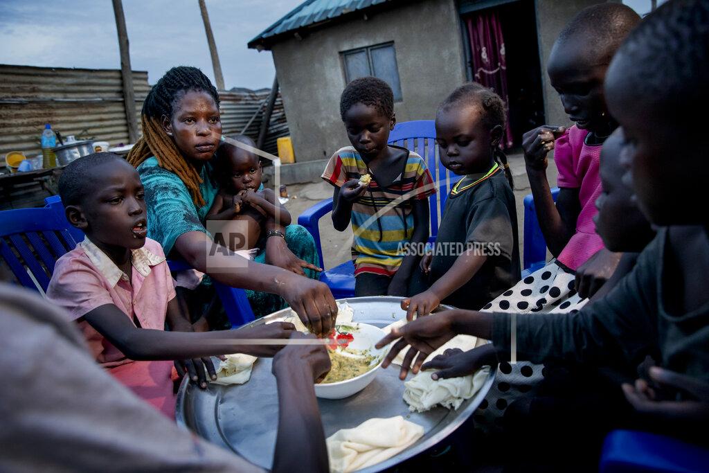 Adrienne Surprenant Paska Itwari Beda, the young mother of five children, shares a meal with her family at her Juba, South Sudan home, Thursday, May 27, 2021. The young mother of five children - all of them under age 10 - sometimes survives on one bowl of porridge a day, and her entire family is lucky to scrape together a single daily meal, even with much of the money Beda makes cleaning offices going toward food. (AP Photo/Adrienne Surprenant)
