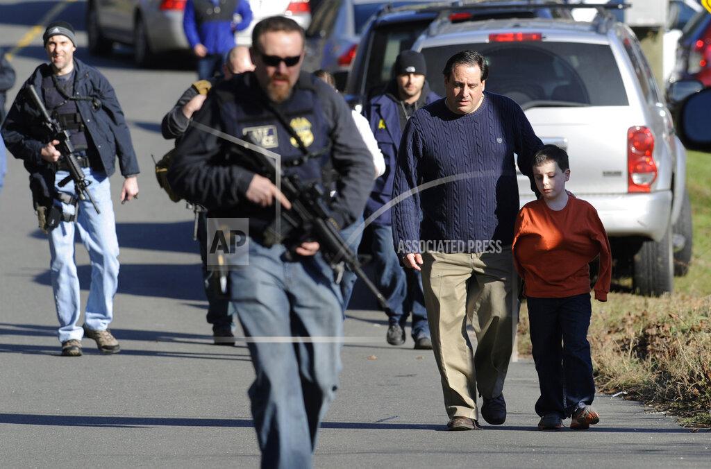 Jessica Hill FILE - Parents leave a staging area after being reunited with their children following a shooting at the Sandy Hook Elementary School in Newtown, Conn. where authorities say a gunman opened fire, leaving 27 people dead, including 20 children, Friday, Dec. 14, 2012. After a weekend of gun violence in America, Saturday, May 14, 2022, when shootings killed and wounded people grocery shopping, going to church and simply living their lives, the nation marked a milestone of 1 million deaths from COVID-19. The number, once unthinkable, is now a pedestrian reality in the United States, just as is the reality of the continuing epidemic of gun violence that kills tens of thousands of people a year. (AP Photo/Jessica Hill, File)