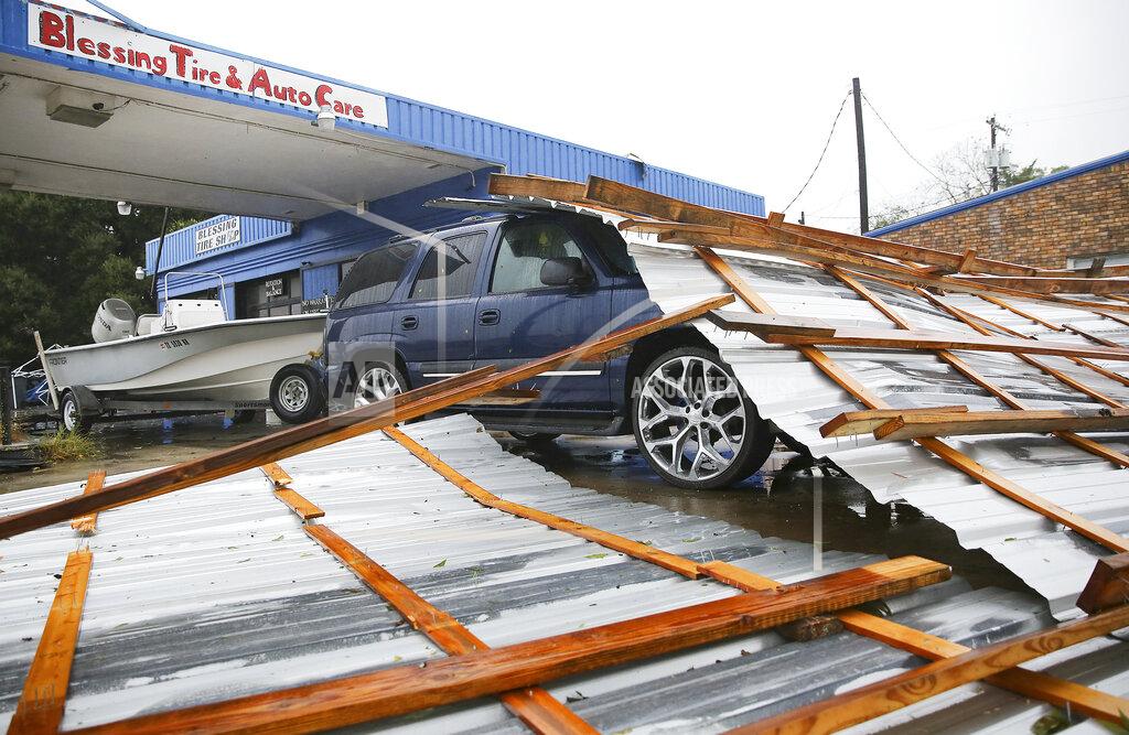 Elizabeth Conley Parts of a roof sit on top of a car parked at Blessings Tire and Auto Care following Hurricane Nicholas in Bay City, Texas on Tuesday, Sept. 14, 2021. According to the owner of the business, he wasn't sure where the roof came from. (Elizabeth Conley/Houston Chronicle via AP)