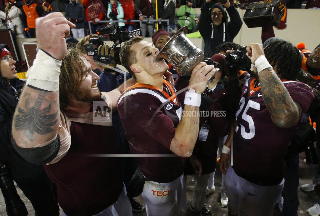 Steve Helber Virginia Tech quarterback Ryan Willis, center, drinks from the Commonwealth Cup after his team defeated Virginia 34-31 in overtime of an NCAA college football game in Blacksburg, Va., Friday, Nov. 23, 2018. (AP Photo/Steve Helber)