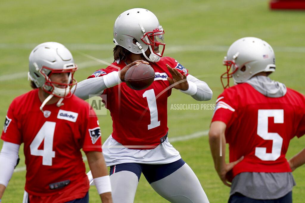 New England Patriots quarterback Cam Newton throws a pass as Jarrett Stidham (4) and Brian Hoyter (5) look on during NFL football practice in Foxborough, Mass., Friday, June 4, 2021. (AP Photo/Mary Schwalm)
