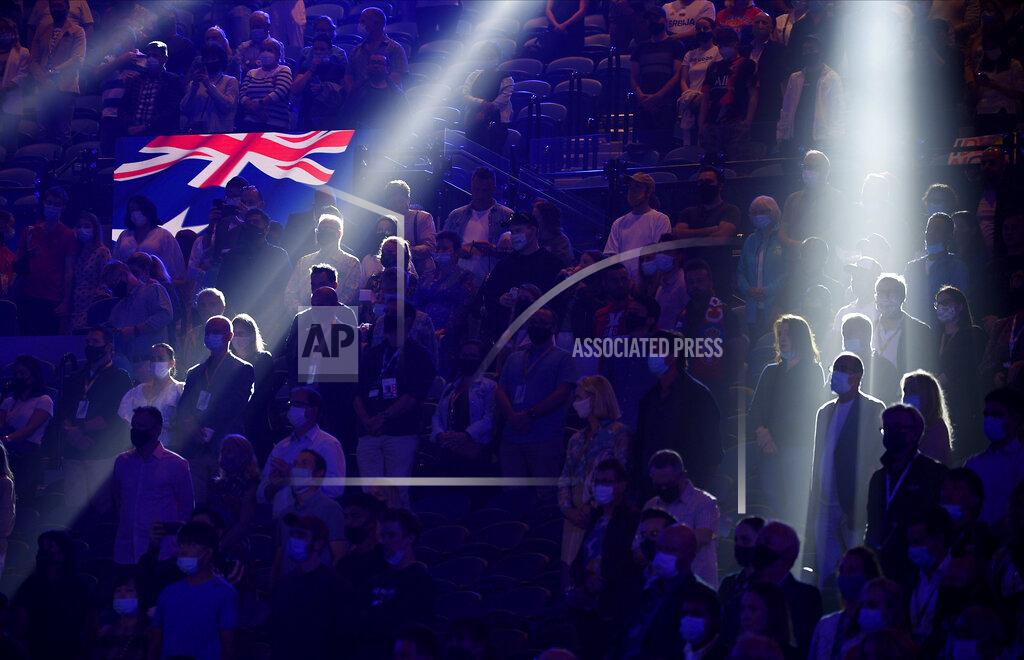 Andy Brownbill Spectators stand for the Australian national anthem ahead of the men's singles final Serbia's Novak Djokovic and Russia's Daniil Medvedev at the Australian Open tennis championship in Melbourne, Australia, Sunday, Feb. 21, 2021.(AP Photo/Andy Brownbill)