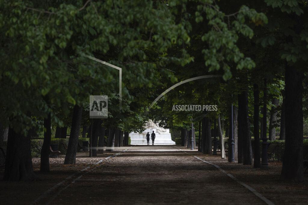 Bernat Armangue A couple walk through the Retiro park in Madrid, Spain, Monday, May 25, 2020. Roughly half of the population, including residents in the biggest cities of Madrid and Barcelona, are entering phase 1 on Monday, which allows social gatherings in limited numbers, restaurant and bar service with outdoor sitting and some cultural and sports activities. (AP Photo/Bernat Armangue)