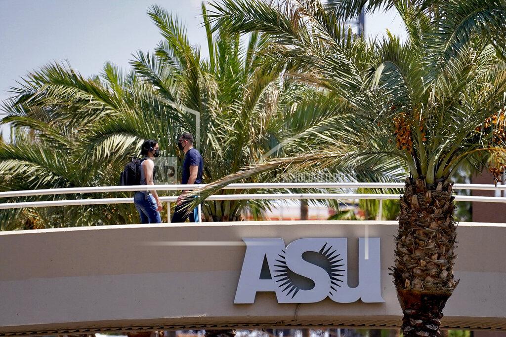 Matt York People use a footbridge over University Avenue on the campus of Arizona State University on Tuesday, Sept. 1, 2020, in Tempe, Ariz. Officials in college towns all over the U.S. are fretting that off-campus students are being counted in places other than the communities where their schools are located. (AP Photo/Matt York)