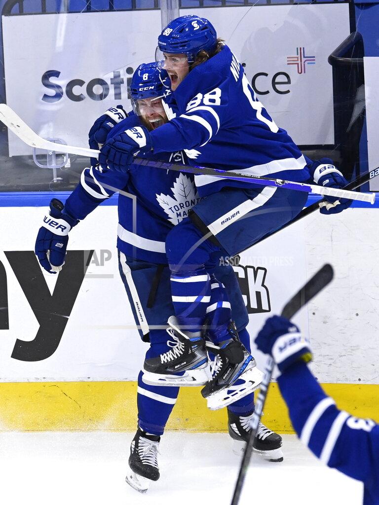 Frank Gunn Toronto Maple Leafs defenseman Jake Muzzin (8) celebrates his goal against the Montreal Canadiens with William Nylander (88) during the third period in Game 5 of an NHL hockey Stanley Cup first-round playoff series in Toronto on Thursday, May 27, 2021. (Frank Gunn/The Canadian Press via AP)
