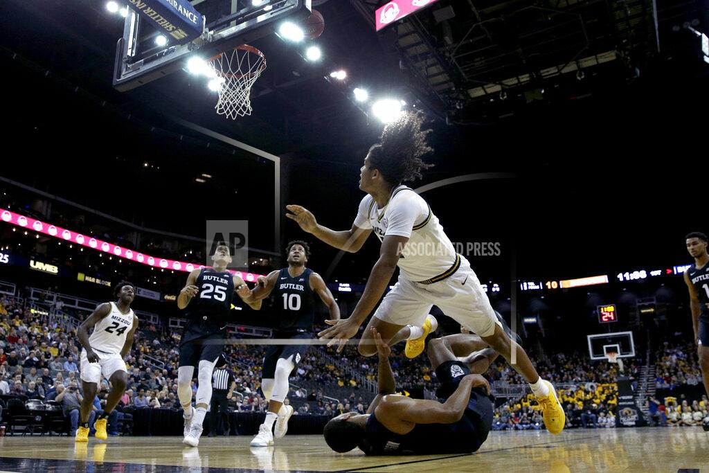 Charlie Riedel Missouri guard Dru Smith, front top right, dives over Butler guard Aaron Thompson, front bottom right, after shooting during the first half of an NCAA college basketball game Monday, Nov. 25, 2019, in Kansas City, Mo. (AP Photo/Charlie Riedel)