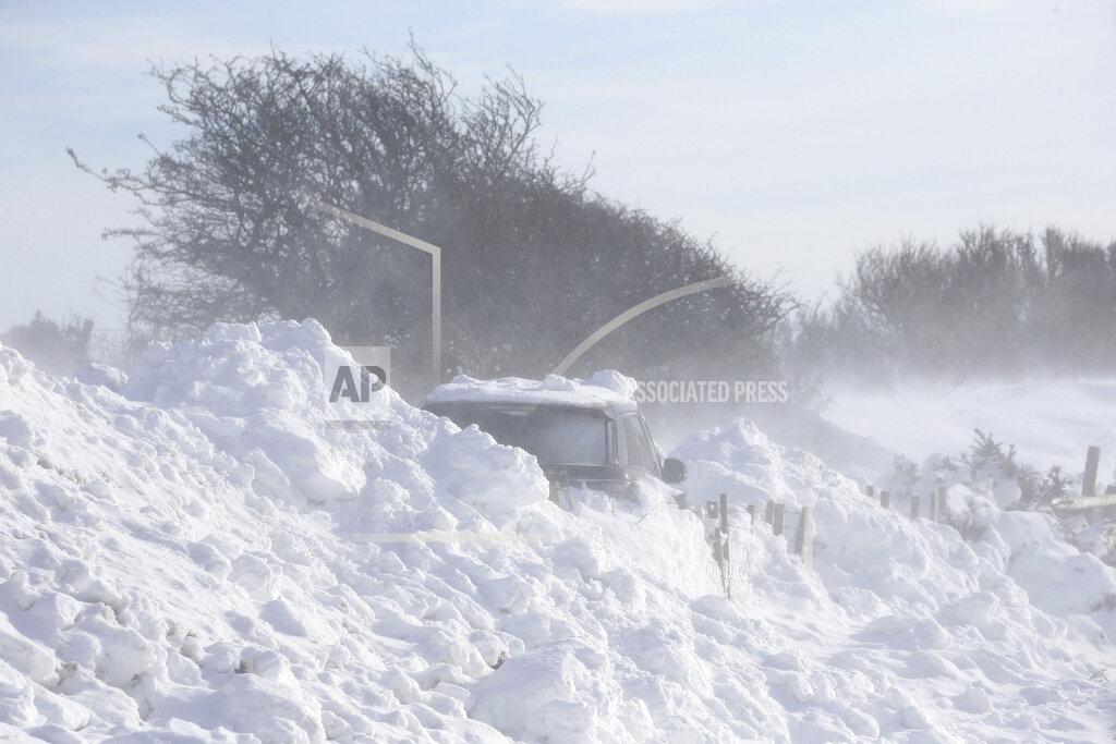 Gareth Fuller A car is buried under drifting snow on a hillside near the sea in southern Folkestone, England, Friday Feb. 12, 2021. The cold snap continues to grip much of the nation Friday. (Gareth Fuller/PA Wire( /PA via AP)