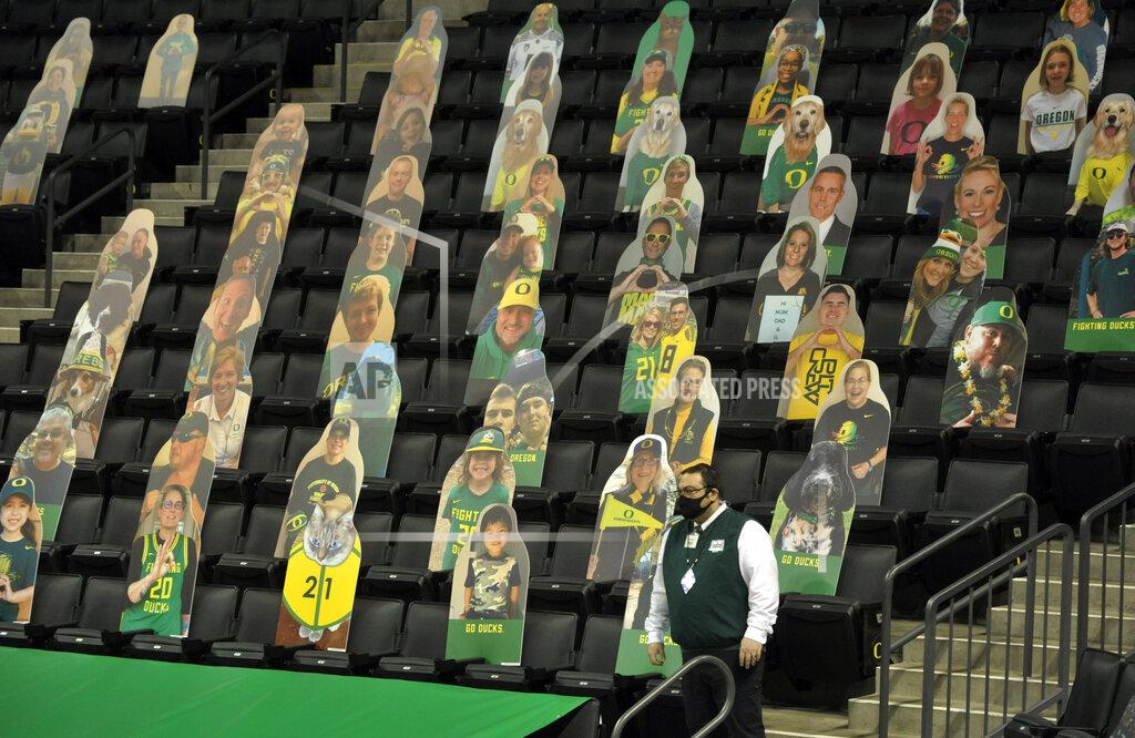 Andy Nelson An usher stands his post despite the cancellation of the NCAA college basketball game between Oregon and UCLA, Wednesday, Dec. 23, 2020, at Matthew Knight Arena in Eugene, Ore. (AP Photo/Andy Nelson)