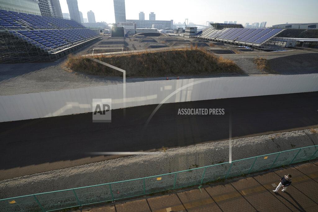 Eugene Hoshiko A man walks past Ariake Urban Sports Park, one of the venues of Tokyo 2020 Olympic and Paralympic games, in Tokyo Thursday, Jan. 21, 2021. The postponed Tokyo Olympics are to open in just six months. Local organizers and the International Olympic Committee say they will go ahead on July 23. But it’s still unclear how this will happen with virus cases surging in Tokyo and elsewhere around the globe. (AP Photo/Eugene Hoshiko)