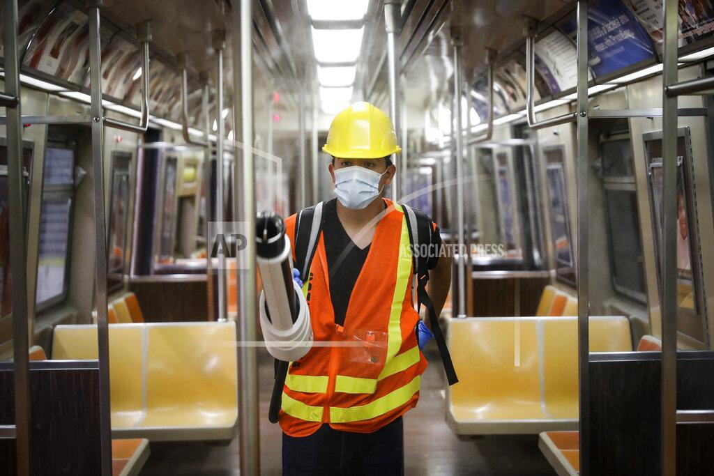 John Minchillo A contractor uses an electrostatic sprayer to disinfect subway cars at the 96th Street station to control the spread of COVID-19, Thursday, July 2, 2020, in New York. Mass transit systems around the world have taken unprecedented — and expensive — steps to curb the spread of the coronavirus, including shutting down New York subways overnight and testing powerful ultraviolet lamps to disinfect seats, poles and floors. (AP Photo/John Minchillo)