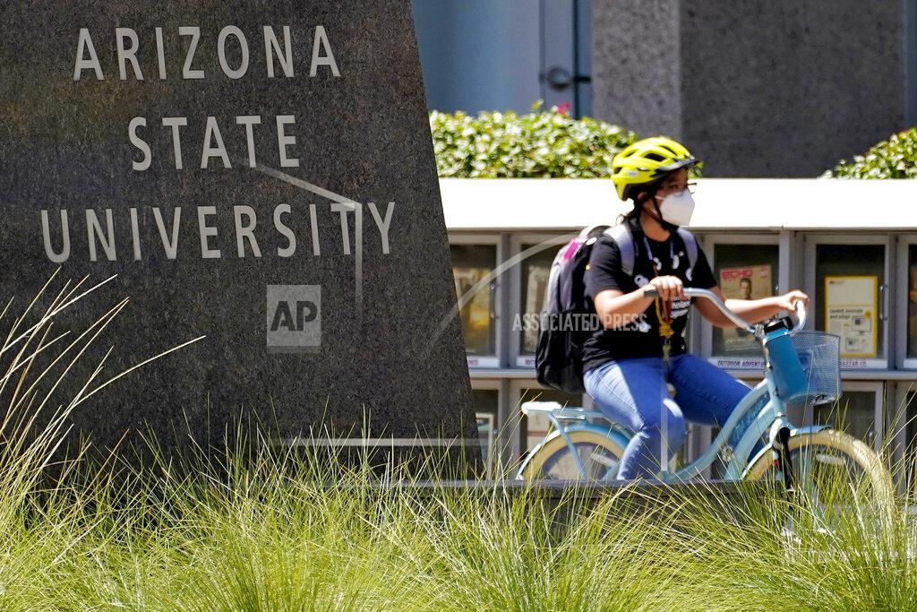 Matt York A cyclist crosses an intersection on the campus of Arizona State University on Tuesday, Sept. 1, 2020, in Tempe, Ariz. Officials in college towns all over the U.S. are fretting that off-campus students are being counted in places other than the communities where their schools are located. (AP Photo/Matt York)