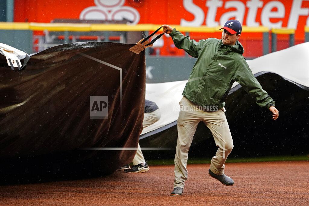 John Bazemore Members of the Atlanta Braves grounds crew work to cover the infield before a baseball game between Atlanta Braves and Colorado Rockies was cancelled because of rain Thursday, Sept. 16, 2021, in Atlanta. (AP Photo/John Bazemore)