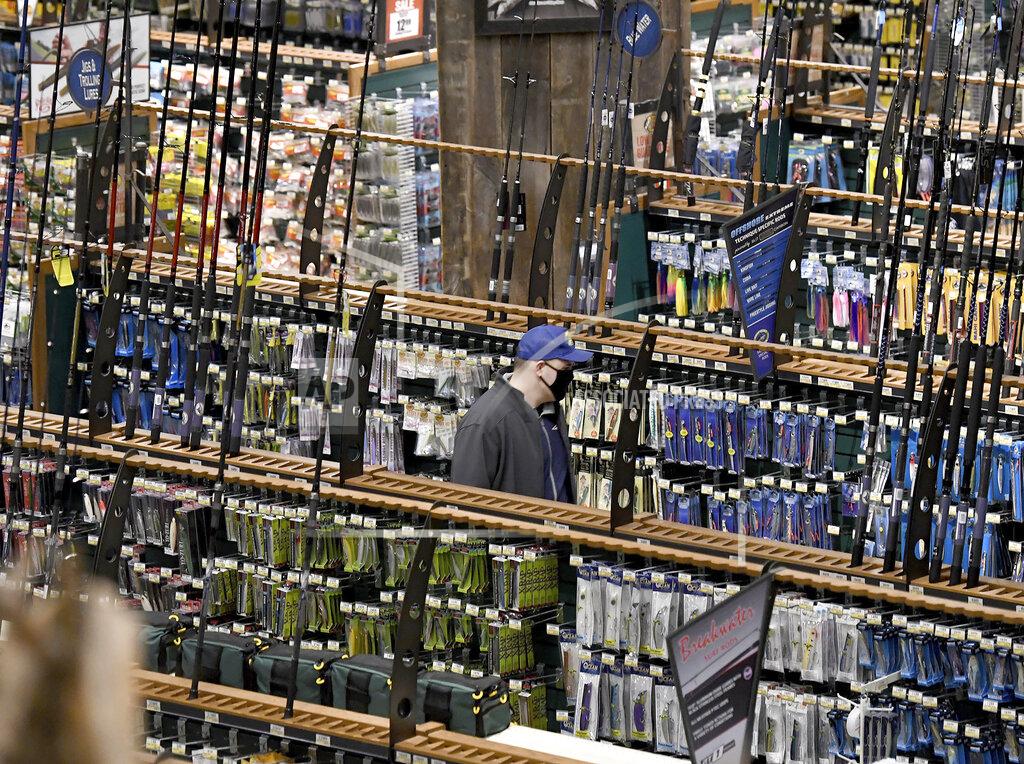 Mark Stockwell / The Sun Chronicle A shopper peruses an aisle of fishing rods and accessories during Black Friday at Bass Pro Shops in Foxboro, Mass. Friday, Nov. 27, 2020. The outdoor specialty store opened their doors at 5 a.m. (Mark Stockwell /The Sun Chronicle via AP)