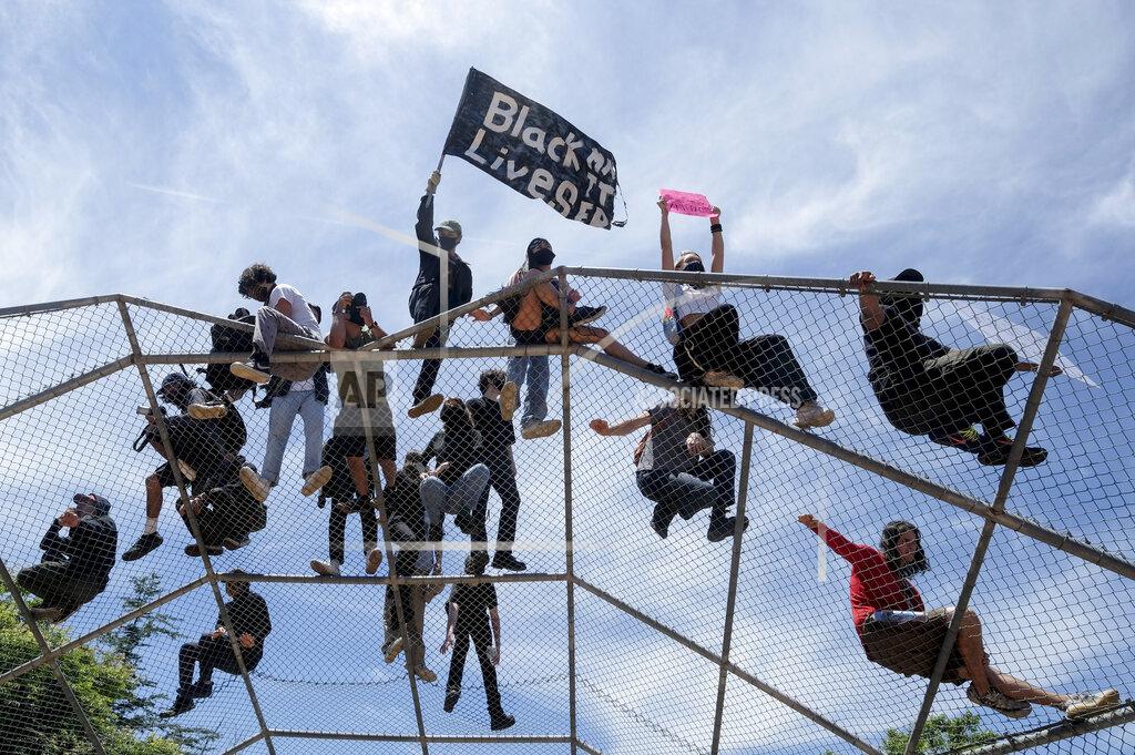 Ringo H.w. Chiu People stand on top of a baseball backstop during a protest over the death of George Floyd in Los Angeles, Saturday, May 30, 2020. Protests across the country have escalated over the death of George Floyd who died after being restrained by Minneapolis police officers on Memorial Day, May 25. (AP Photo/Ringo H.W. Chiu)