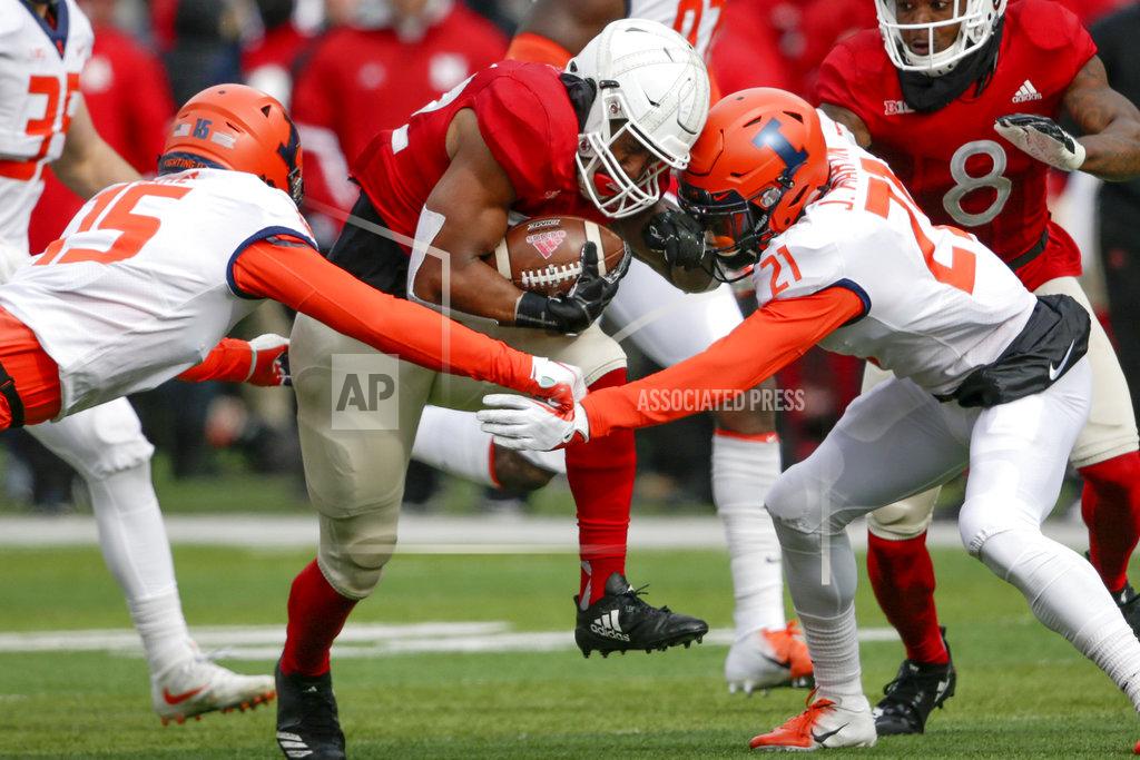 Nati Harnik Nebraska running back Devine Ozigbo (22) carries the ball between Illinois defensive backs Delano Ware (15) and Jartavius Martin (21) during the first half of an NCAA college football game in Lincoln, Neb., Saturday, Nov. 10, 2018. (AP Photo/Nati Harnik)
