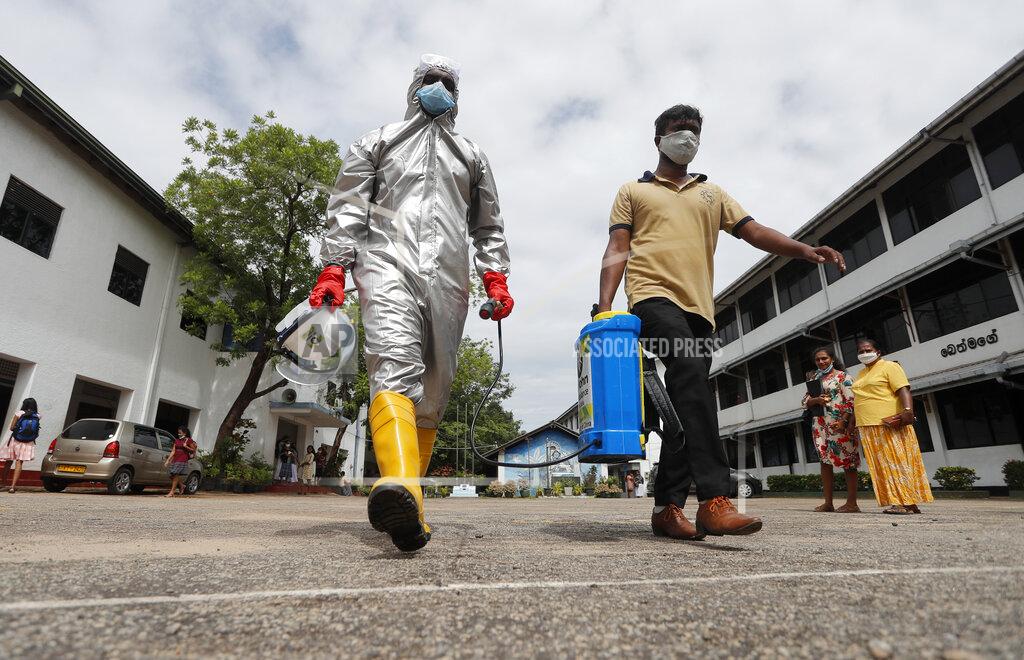 Eranga Jayawardena Members of Sri Lanka's St John's ambulance service carry a can of disinfectants as they spray them in a public school to prevent the spread of coronavirus in Colombo, Sri Lanka, Monday, June 22, 2020. (AP Photo/Eranga Jayawardena)