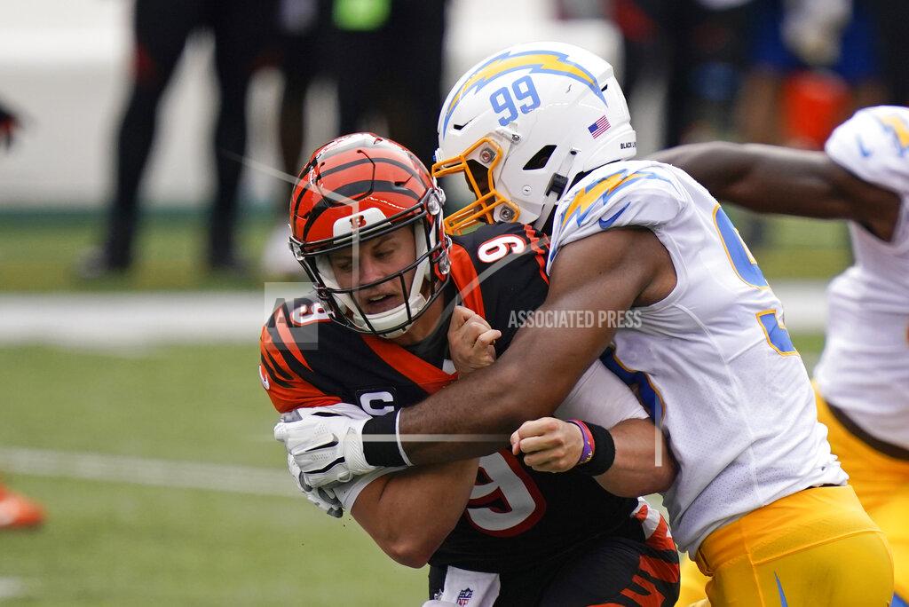 Bryan Woolston Cincinnati Bengals quarterback Joe Burrow (9) is hit by Los Angeles Chargers' Jerry Tillery (99) after a pass during the first half of an NFL football game, Sunday, Sept. 13, 2020, in Cincinnati. (AP Photo/Bryan Woolston)
