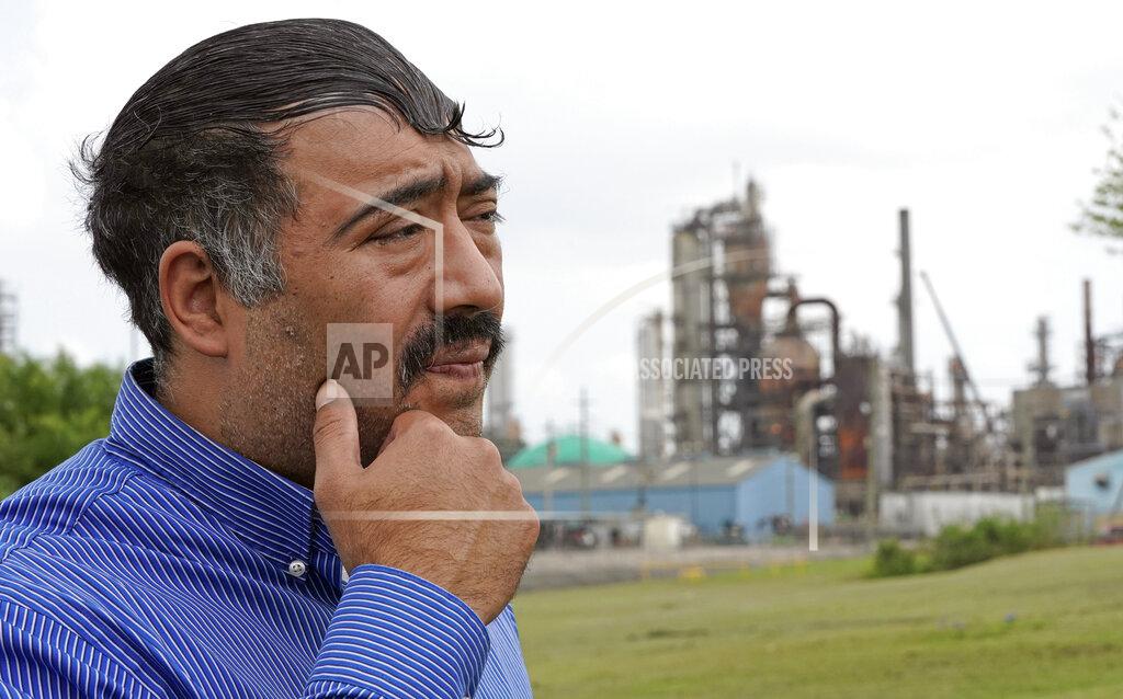 David J. Phillip Juan Flores pauses while poses for a photograph while standing in a small park near a refinery along the Houston Ship Channel Monday, March 23, 2020, in Houston. Flores is working on a project to install air monitors at schools, not to warn children when the air was too bad to play outside, but alert them when plant emissions were low enough to make that safe. (AP Photo/David J. Phillip)