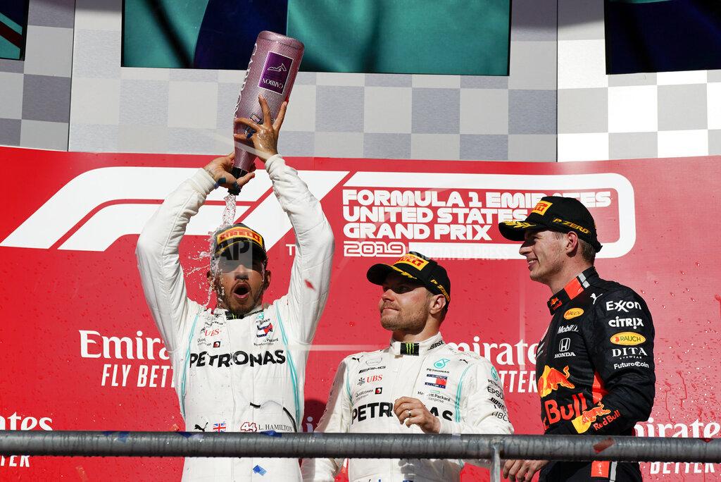 Chuck Burton Mercedes driver Lewis Hamilton, left, of Britain, celebrates as Mercedes driver Valtteri Bottas, middle, of Finland, and Red Bull driver Max Verstappen, of the Netherlands, watch following the Formula One U.S. Grand Prix auto race at the Circuit of the Americas, Sunday, Nov. 3, 2019, in Austin, Texas. (AP Photo/Chuck Burton)
