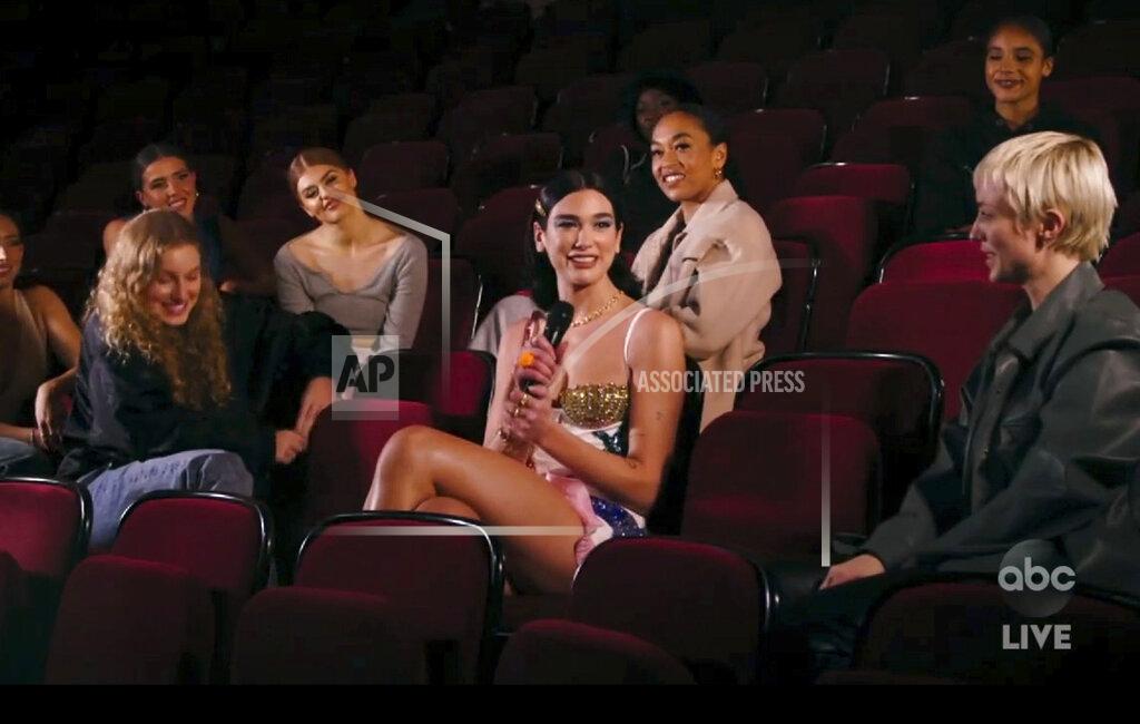 Uncredited In this screen shot provided by ABC on Sunday, Nov. 22, 2020, Dua Lipa, center, accepts the award for favorite pop/rock song for "Don't Start Now" at the American Music Awards at the Microsoft Theater in Los Angeles. (ABC via AP)