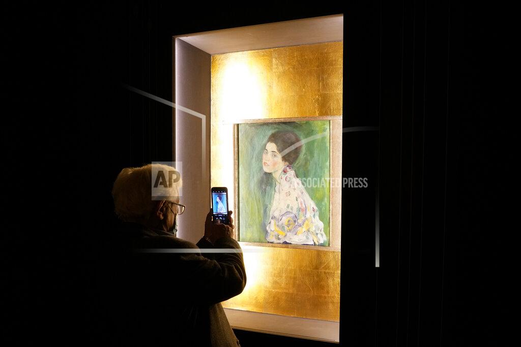 Andrew Medichini A woman takes a photo of Gustav Klimt's oil on canvas painting "Portrait of a Lady" (1916/17) on display at the exhibition "Klimt. The Secession and Italy" at the Museum of Rome, in Palazzo Braschi, Rome, during a press preview, Tuesday, Oct. 26, 2021. The exhibition, that explores Klimt's period in Italy, will be open to visitors from Oct.27, 2021 to March 27, 2022. (AP Photo/Andrew Medichini)