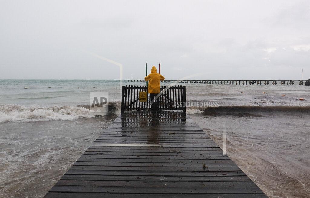 Victor Ruiz Garcia A man takes pictures of the sea during the passing of Hurricane Delta in Cancun, Mexico, Wednesday, Oct. 7, 2020. Hurricane Delta made landfall Wednesday just south of the Mexican resort of Cancun as a Category 2 storm, downing trees and knocking out power to some resorts along the northeastern coast of the Yucatan Peninsula. (AP Photo/Victor Ruiz Garcia)