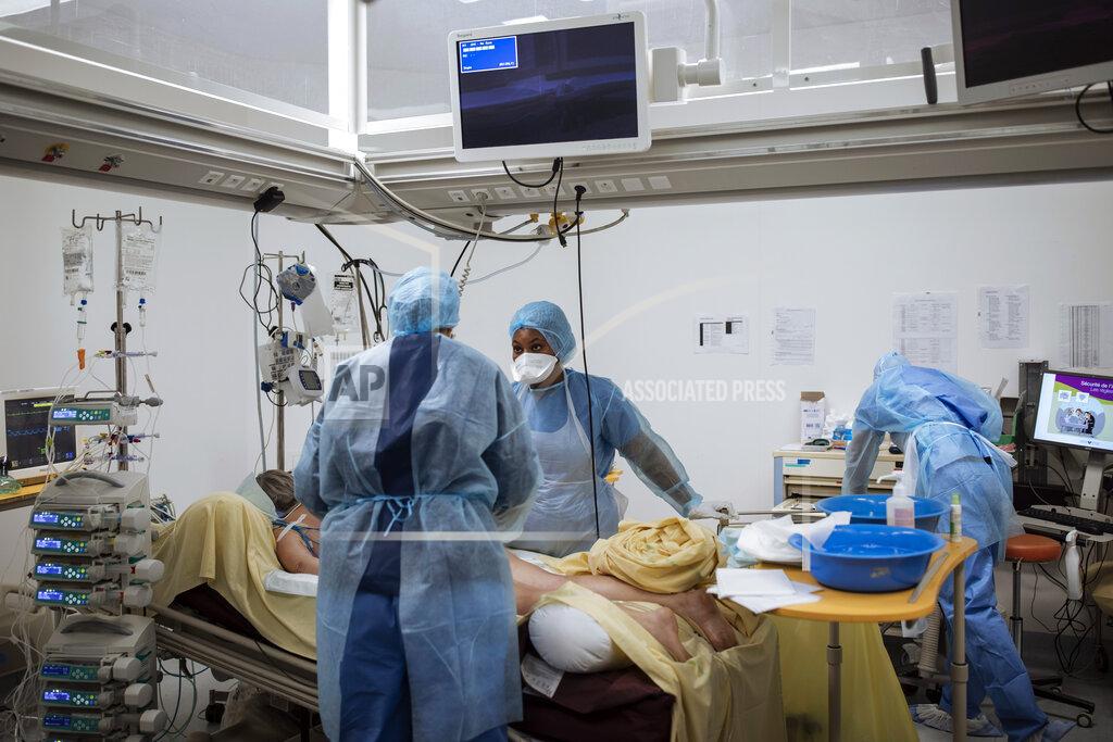 Lewis Joly Nurse Yevana Faro, center, cares for a patient inside an operating room now used for unconscious COVID-19 patients at Bichat Hospital, AP-HP, in Paris, Thursday, April 22, 2021. France still had nearly 6,000 critically ill patients in ICUs this week as the government embarked on the perilous process of gingerly easing the country out of its latest lockdown, too prematurely for those on pandemic frontlines in hospitals. President Emmanuel Macron's decision to reopen elementary schools on Monday and allow people to move about more freely again in May, even though ICU numbers have remained stubbornly higher than at any point since the pandemic's catastrophic first wave, marks another shift in multiple European capitals away from prioritizing hospitals. (AP Photo/Lewis Joly)