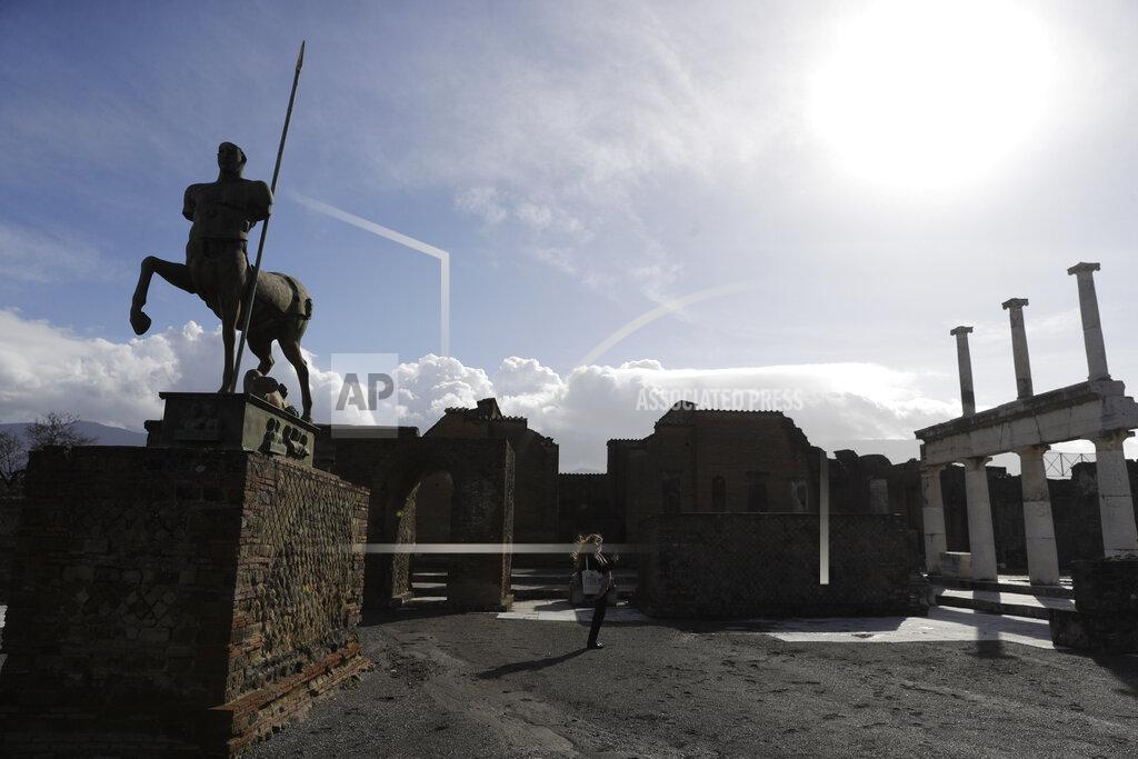 Gregorio Borgia A journalist takes pictures in the archeological site of Pompeii during the inauguration of the museum Antiquarium, in Pompeii, southern Italy, Monday, Jan. 25, 2021. Decades after suffering bombing and earthquake damage, Pompeii's museum is back in business, showing off exquisite finds from excavations of the ancient Roman city. Officials of the archaeological park of the ruins of the city destroyed in 79 A.D. by the eruption of Mount Vesuvius inaugurated the museum on Monday. (AP Photo/Gregorio Borgia)