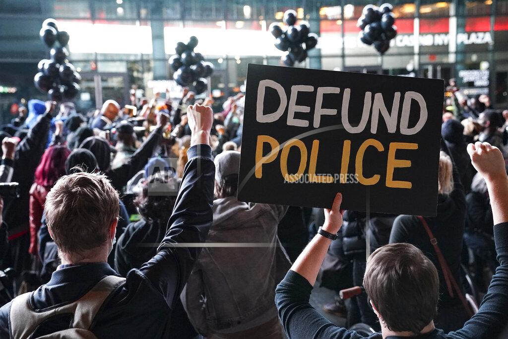 John Minchillo FILE - In this Wednesday, Oct. 14, 2020, file photo, a protester holds a sign that reads "Defund Police" during a rally for the late George Floyd outside Barclays Center, in New York. Demonstrators gathered on what would have been Floyd's 47th birthday to call for action in correcting systemic racism in policing and for criminal justice reform. Responses to the coronavirus pandemic and police brutality dominated legislative sessions in 2020 and led to many new laws that will take effect in the new year. (AP Photo/John Minchillo, File)