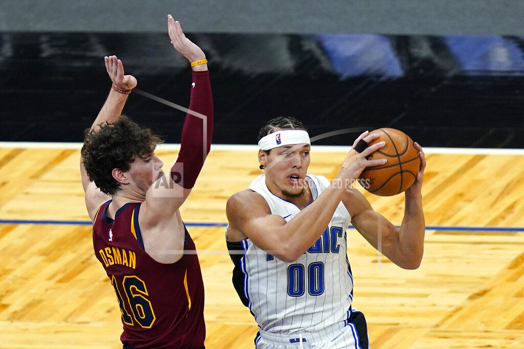 John Raoux Orlando Magic forward Aaron Gordon (00) looks to pass the ball as he his path to the basket is guarded by Cleveland Cavaliers forward Cedi Osman (16) during the first half of an NBA basketball game, Monday, Jan. 4, 2021, in Orlando, Fla. (AP Photo/John Raoux)