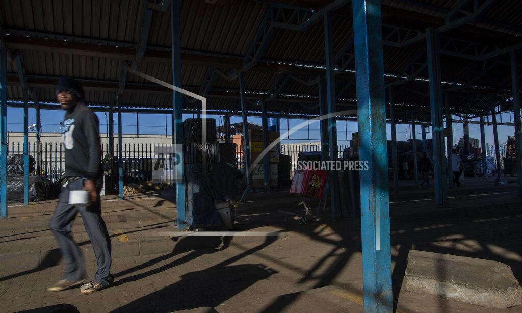 Themba Hadebe A stranded commuter walks away from a deserted taxi rank in Katlehong, South Africa, Monday, June 22, 2020, as taxi drivers affiliated to the SA National Taxi Council (Santaco) protested against what it believes to be insufficient government relief offered to the industry. South Africa's largest city, Johannesburg, has been hit by a strike by mini-bus taxis, preventing many thousands of people from getting to work on Monday, as the country reopens its economy even as cases of COVID-19 are increasing. (AP Photo/Themba Hadebe)