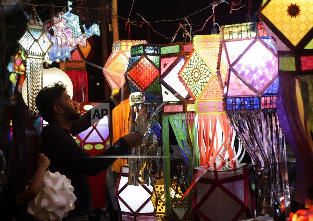 Rajanish Kakade A man displays lanterns for sale as people shop ahead of Diwali festival in Mumbai, India, Thursday, Nov.12, 2020. India's tally of coronavirus cases is currently the second largest in the world behind the United States. The government warns that the situation can worsen due to people crowding markets for festival shopping. (AP Photo/Rajanish Kakade)