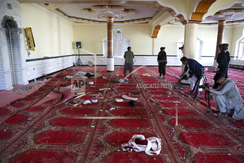 Rahmat Gul Afghan journalist take photos and film inside a mosque after a bomb explosion in Shakar Dara district of Kabul, Afghanistan, Friday, May 14, 2021. A bomb ripped through a mosque in northern Kabul during Friday prayers killing 12 worshippers, Afghan police said. (AP Photo/Rahmat Gul)