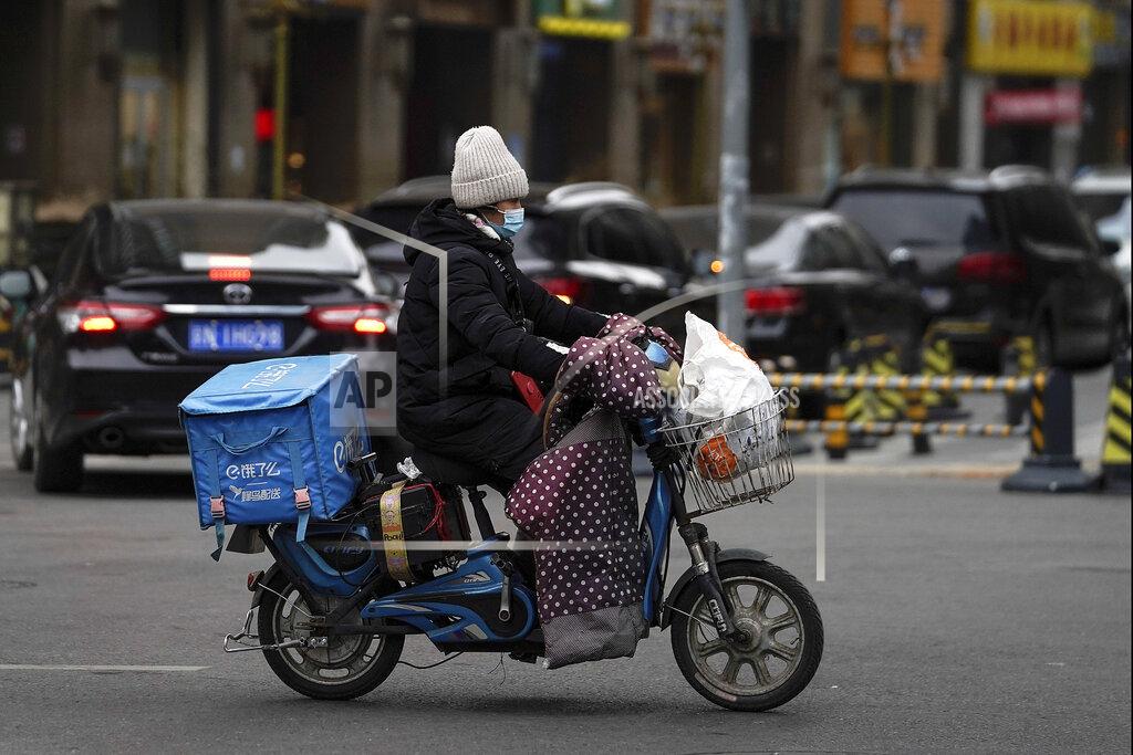 Andy Wong A food delivery worker wearing a face mask to help curb the spread of the coronavirus rides on a street in Beijing on Thursday, Jan. 14, 2021. The e-commerce workers and delivery people who kept China fed during the pandemic, making their billionaire bosses even richer, are so unhappy with their pay and treatment that one just set himself on fire in protest. (AP Photo/Andy Wong)