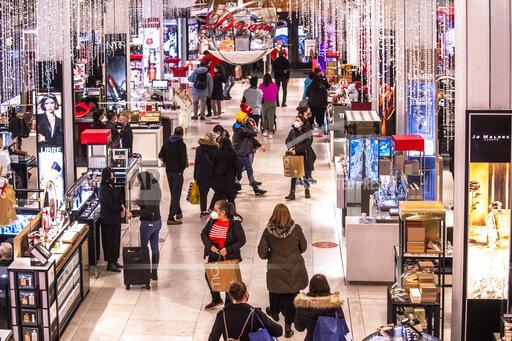FILE - Shoppers walk through Macy's on Nov. 26, 2021, in New York. Americans slowed their spending from November to December as a trifecta of product shortages, surging prices and a surge of the highly contagious omicron curtailed spending. Retail sales fell 1.9% in December compared with the previous month when sales increased 0.3%, the U.S. Commerce Department said Friday, Jan. 14, 2022. (AP Photo/Brittainy Newman, File)