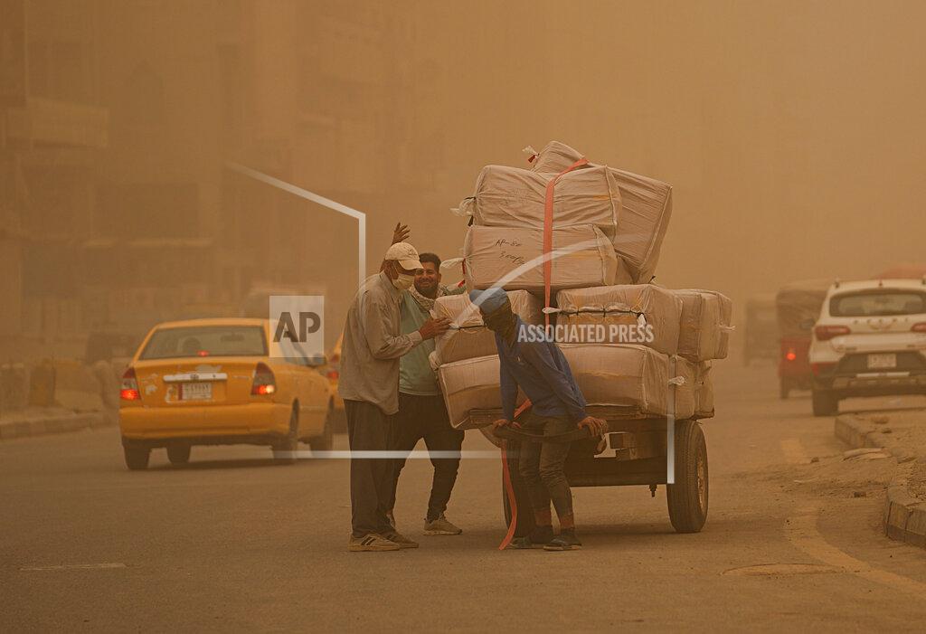 Hadi Mizban People push a cart during a sandstorm in Baghdad, Iraq, Monday, May 23, 2022. (AP Photo/Hadi Mizban)