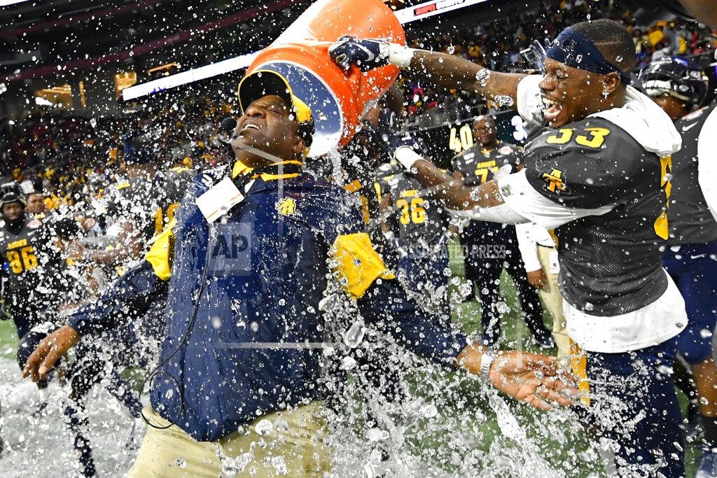 John Amis North Carolina A&T coach Sam Washington is doused by defensive back Jalon Bethea during the final seconds of the Celebration Bowl NCAA college football game against Alcorn State, Saturday, Dec. 21, 2019, in Atlanta. North Carolina A&T won 64-44. (John Amis/Atlanta Journal-Constitution via AP)