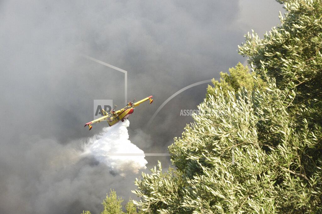 Andreas Alexopoulos An airplane drops water over a wildfire near Lampiri village, west of Patras, Greece, Saturday, Jul. 31, 2021. The fire, which started high up on a mountain slope, has moved dangerously close to seaside towns and the Fire Service has send a boat to help in a possible evacuation of people. (AP Photo/Andreas Alexopoulos)