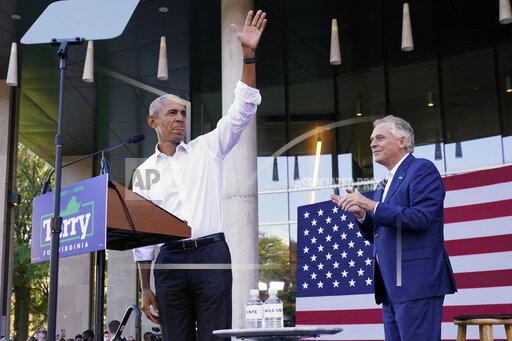 Former President Barack Obama, left, waves during a rally with Democratic gubernatorial candidate, former Virginia Gov. Terry McAuliffe, right, in Richmond, Va., Saturday, Oct. 23, 2021. McAuliffe will face Republican Glenn Youngkin in the November election. (AP Photo/Steve Helber)