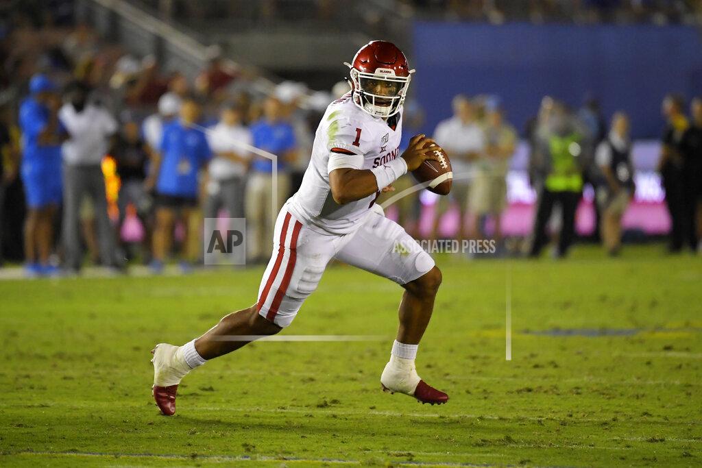 Mark J. Terrill FILE - In this Sept. 14, 2019, file photo, Oklahoma quarterback Jalen Hurts runs the ball during the second half of an NCAA college football game against UCLA in Pasadena, Calif. While Oklahoma appears to have another serious Heisman contender with Big 12 newcomer and dual-threat graduate transfer Jalen Hurts, the Longhorns have one of the eight underclassmen starting quarterbacks in the league. Texas junior Sam Ehlinger is off to a record-setting pace that could also get him in that Heisman conversation.(AP Photo/Mark J. Terrill, File)