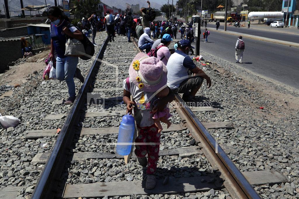 Martin Mejia A child walks on a track holding a doll as day laborers and informal workers who usually eke a living in Peru's capital congregate on the side of a highway as they are blocked from returning home by a cordon of police on the outskirts of Lima, Peru, Friday, April 17, 2020. Because the strict quarantine rules amid the new coronavirus pandemic do not allow for inter-province travel, the workers have been living on the side of the road for three days. (AP Photo/Martin Mejia)
