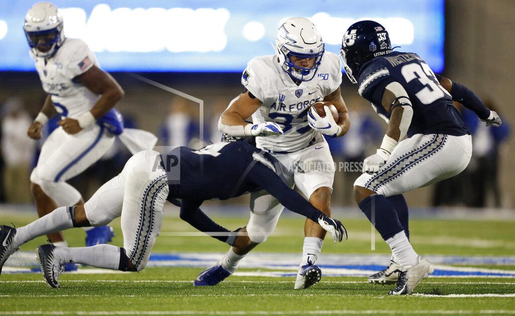 David Zalubowski FILE--In this Oct. 26, 2019, file photo, Air Force fullback Taven Birdow, center, is stopped by Utah State safety Shaq Bond, left, and linebacker Kevin Meitzenheimer during the second half of an NCAA college football game at Air Force Academy, Colo. Birdow's father, Jermaine, saw for the first time his son play football when Air Force hosted Army on Saturday, Nov. 2. (AP Photo/David Zalubowski, File)