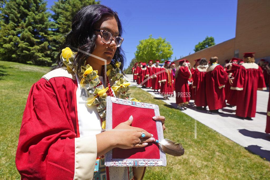 Rick Bowmer Amryn Tom holds her beaded graduation cap and eagle feather during her graduation from Cedar City High School on Wednesday, May 25, 2022, in Cedar City, Utah. Tom is wearing an eagle feather given to her by her mother and a cap that a family friend beaded. (AP Photo/Rick Bowmer)